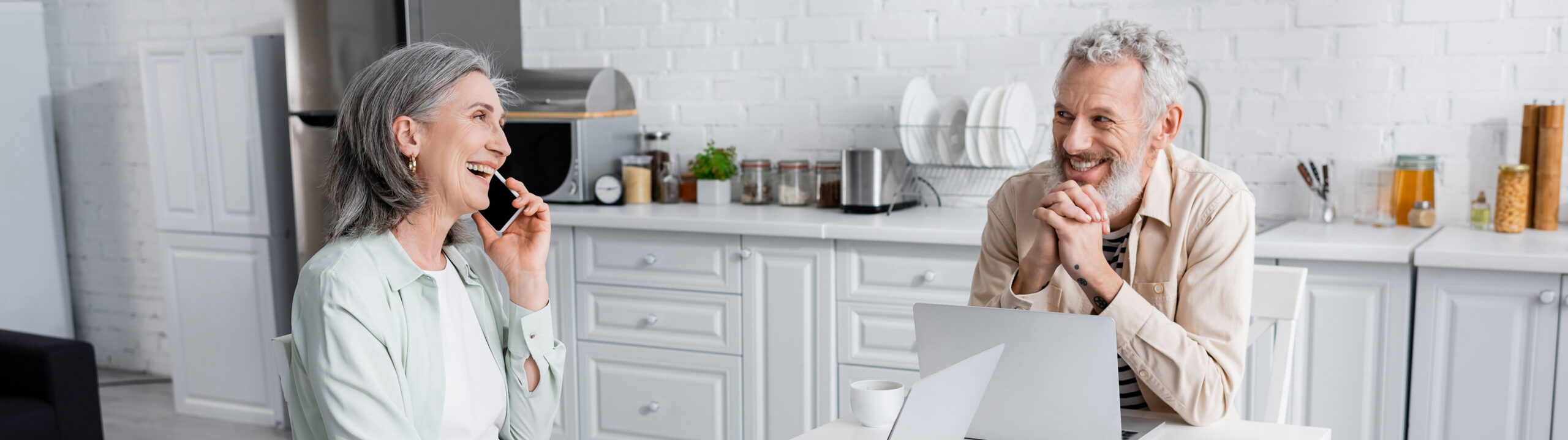 Smiling,Man,Looking,At,Cheerful,Wife,Talking,On,Cellphone,Near