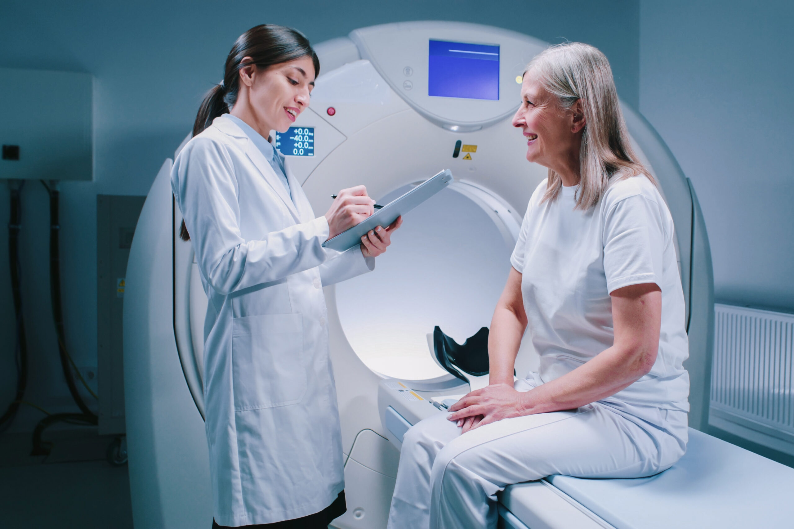 Remote,Shooting.,Female,Doctor,Is,Standing,Near,Patient,And,Explaining